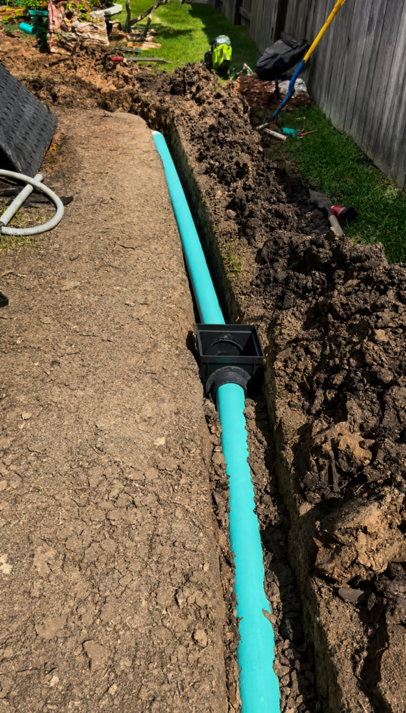 Drainage pipe installed in a professionally excavated trench for a residential yard drainage system, ensuring efficient, water flow and long-term term performance.