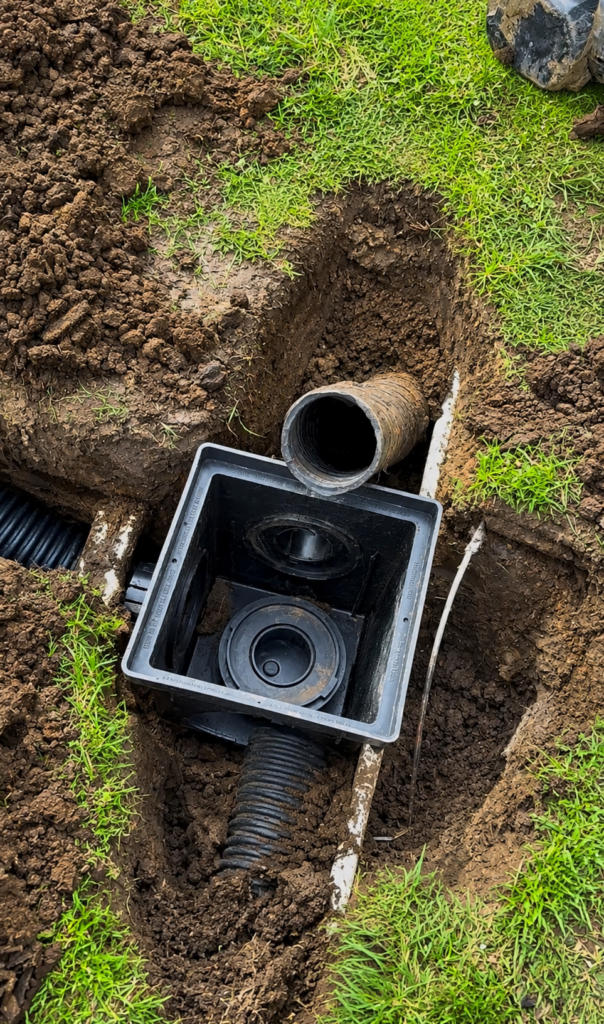 Catch basin installation connecting a drainage pipe to improve your drainage and direct stormwater away from the property.